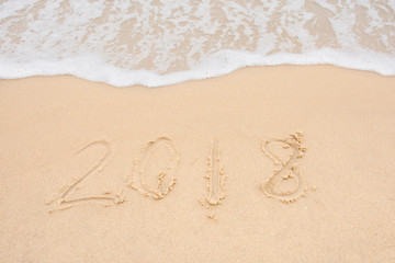 Soft wave and Number 2018 of sea on empty sandy beach Background with copy space