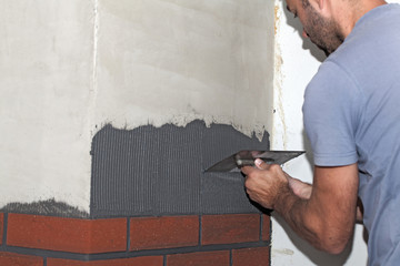 Man cement is applied with a trowel.