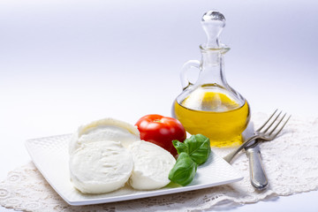Soft white Italian cheese Mozzarella buffalo served with fresh tomato, olive oil and green basil...
