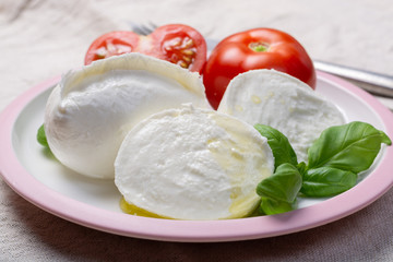 Soft white Italian cheese Mozzarella buffalo served with fresh tomato and green basil leaves