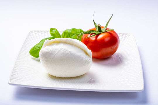 Soft white Italian cheese Mozzarella buffalo served with fresh tomato and green basil leaves