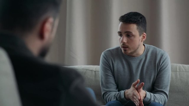 Young man talking to his therapist at therapy session