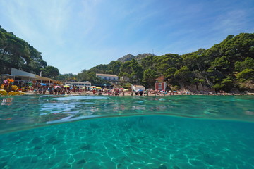 Spain Mediterranean sea summer vacation at beach, Aiguablava, split view above and below water surface, Catalonia, Costa Brava