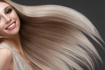 Beautiful blond girl in move with a perfectly smooth hair, and classic make-up. Beauty face.