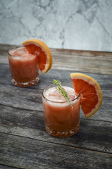 Grapefruit and rosemary gin tonic  cocktail, refreshing drink with ice on wooden background