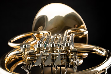 French horn on a wooden table. Beautiful polished musical instrument. © Piotr