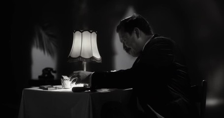 Gentleman taking a sip from his fancy whiskey glass as he is writing