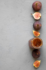 Obraz na płótnie Canvas Top view, fig jam in glass jar and fresh figs on concrete background. Flat lay, from above, overhead. Copy space.