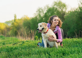 Portrait of young beautiful woman lying and hugging her golden retriever dog. Happiness and friendship. pet and woman.