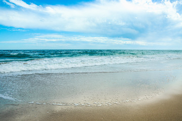Fototapeta na wymiar White sand and blue sea with waves