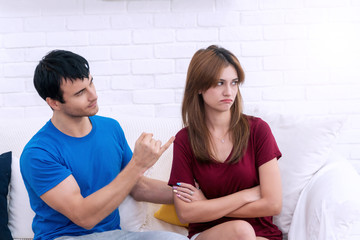 Handsome young man trying to reconcile with his girlfriend after have an argument in living room....