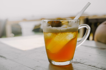 Cold ice tea with dried citrus fruits and cocktail straw tube in the glass