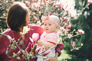 Mother and baby with blooming pink magnolia flower