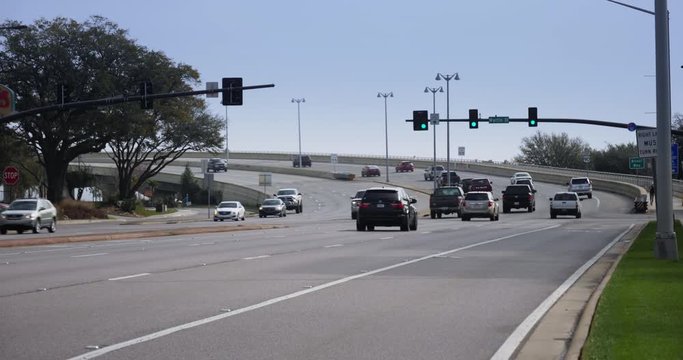 A long shot of traffic on Route 90 Beach Boulevard driving onto the Biloxi Bay Bridge.  	