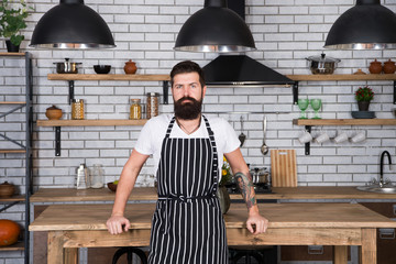 He is a champion in the kitchen. Hipster in kitchen. Mature male. Bearded man cook. Bearded man in...