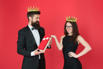 Queen of his heart. Man bearded king in tuxedo golden crown giving gift box to woman elegant dress....
