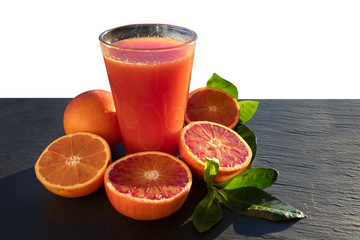Red blood oranges juice on a slate plate isolated image