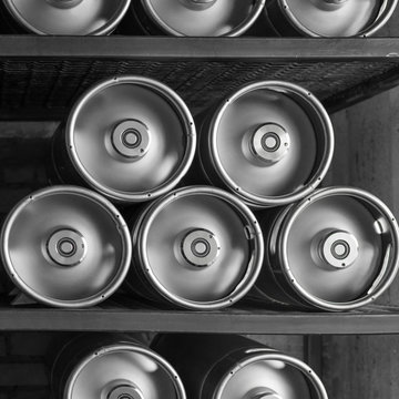 Metal beer kegs lie in a row