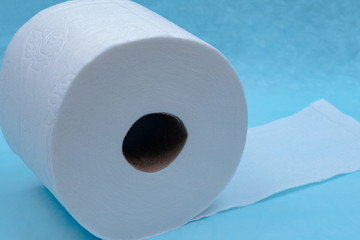 Soft strong and absorbent white toilet paper isolated on blue under pad.