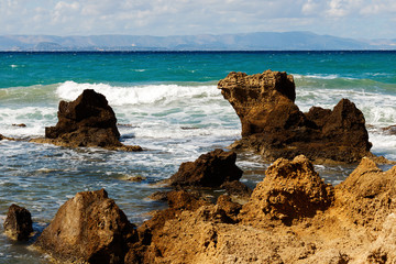 Waves crashing against the rocks.