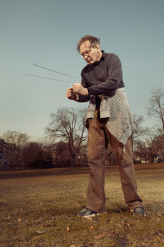 Man in ugly style dress practicing in dowsing with rods