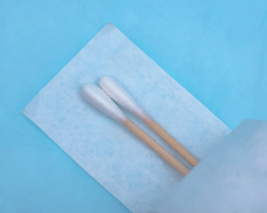 Sterile Long Cotton Tipped Applicators isolated on blue under pad.