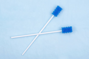 Untreated disposable oral swabs on blue under pad.