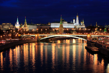 Fototapeta na wymiar Beautiful night view of the Moscow Kremlin and the bridge over the river with the reflection of lights in the water, Russia