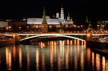 Fototapeta na wymiar Beautiful night view of the Moscow Kremlin and the bridge over the river with the reflection of lights in the water, Russia