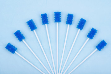 Untreated disposable oral swabs on blue under pad.