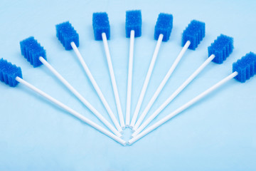Untreated disposable oral swabs on blue under pad.