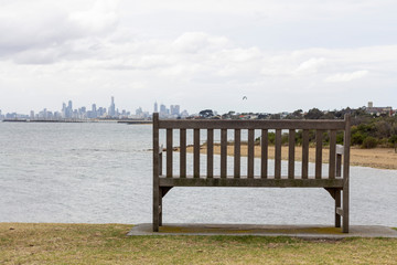 Fototapeta na wymiar Lone wooden bench with horizon landscape to the beach.