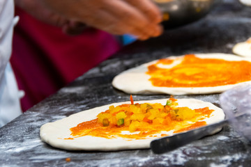 Italian food preparation called Calzone, wheat flour and fresh vegetables and ham.
