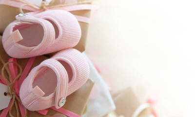 Gifts and pink decorations for girl baby shower indoors. close-up of baby shoes