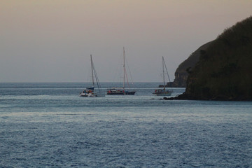 Sailboats anchored at nightfall in a bay of the Mamanuca Islands, Fiji