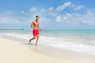 Fototapeta na wymiar Young man running at the beach