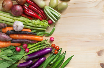 Flat lay view of different colourful raw vegan food on wooden background.