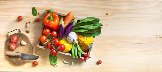 Flat lay view of different colourful raw vegan food on wooden background.