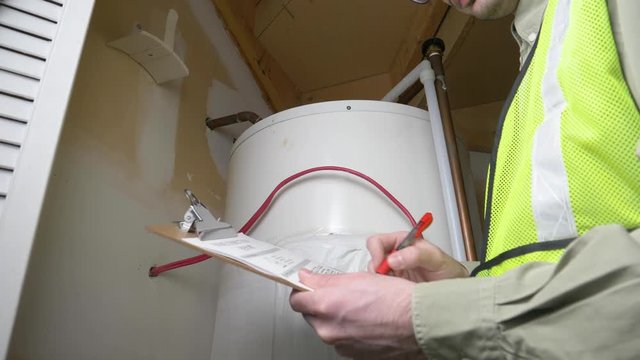 Plumber technician inspecting the warm water heater of a house.