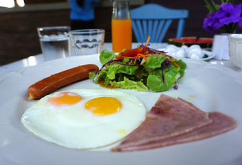 American breakfast serving with fried egg, ham ,sausage and salad