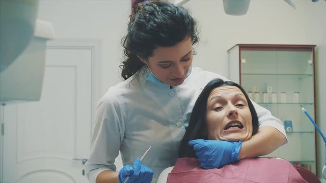 A young girl is admitted to a dentist. During this time she opens her mouth and understands the doctor.