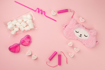 Obraz na płótnie Canvas pink fashion trendy woman's girl set with heart shaped sunglasses, sleep band, tampon, straw, sweetness on candy pink background, sunshine summer concept