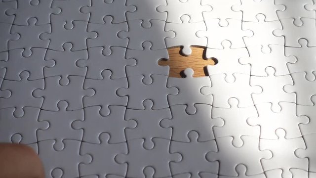 Woman hand putting the last piece in the puzzle