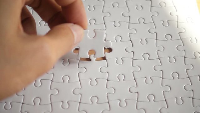Woman hand putting the last piece in the puzzle