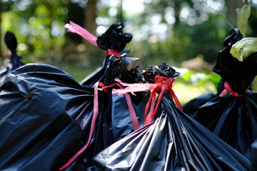 The black garbage bag are tied with yellow and red straw,Garbage dump.