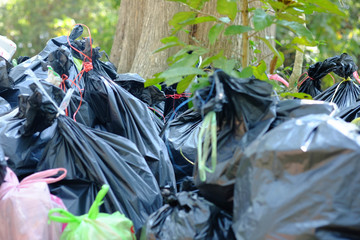 The black garbage bag are tied with yellow and red straw,Garbage dump.