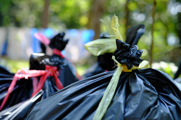 The black garbage bag are tied with yellow and red straw,Garbage dump.