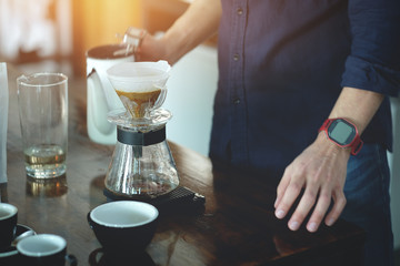 Obraz na płótnie Canvas Barista man making coffee in cafe with vintage light tone 