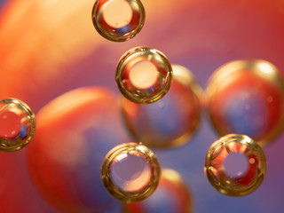Scores of glittering spheres, abstract background. Close up shot. Blurred background. Selective soft focus. Spheres glittering with golden and red lights. Visual for Christmas card. Macro shot