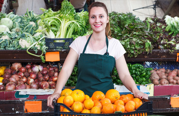 Saleswoman holding oranges in market